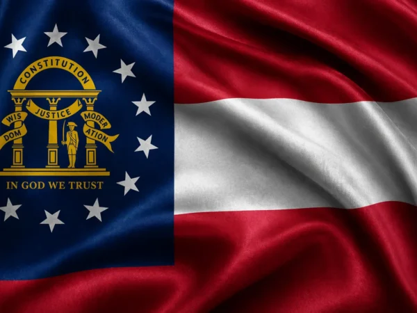 Georgia state flag with blue canton containing the gold state seal and 13 white stars, beside red and white stripes. Georgia Municipalities Personal Injury Lawyers